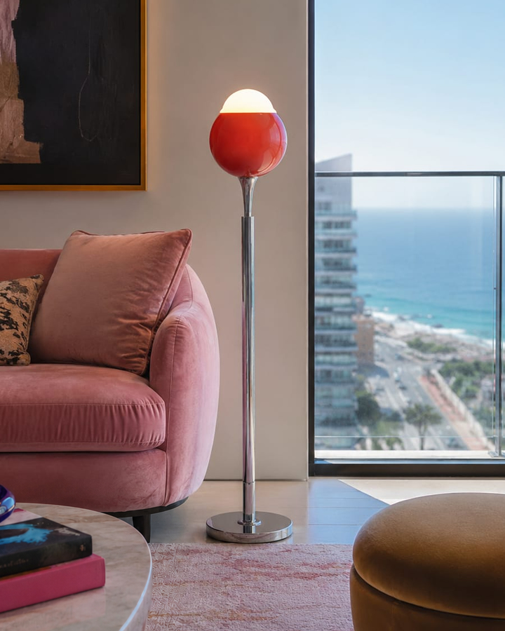No. 001, Ember, a tall floor lamp with a glowing white dome, red rounded shade, slender reflective stem, and circular base.