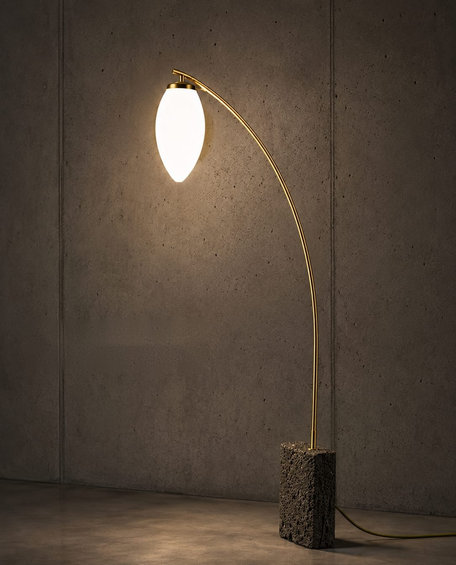 No. 002, Willow, a tall floor lamp with a glowing leaf-shaped opal glass shade, arched brass arm, and rough stone base.