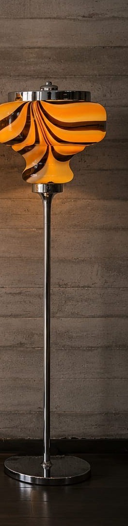 No. 043, Tortoise, a mottled orange-brown glass shade glows atop a slim chrome pole and round base.